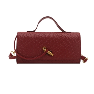 Dark red woven leather handbag with a gold knot buckle and adjustable shoulder strap