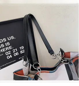 Close-up of contrast color tote bag with black leather handle and silver metal rings