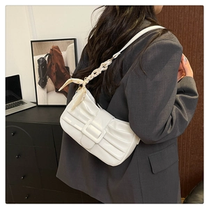 Détail du sac plissé blanc avec boucle carrée et bandoulière en soie à motif floral