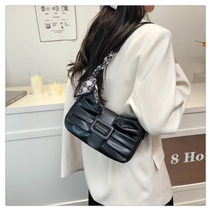 Détail du sac à bandoulière plissé noir avec foulard en soie et boucle décorative chic