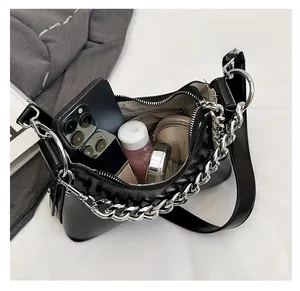 Détail du sac sous le bras en cuir ciré noir montrant l'espace intérieur et la chaîne