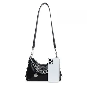 Comparaison de taille du sac à bandoulière noir brillant avec chaîne et un smartphone