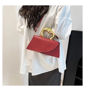 Detail showing deep red woven texture bag with a unique gold swan-shaped metal handle