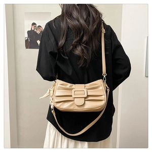Détail du sac à bandoulière plissé abricot avec boucle carrée et détail de foulard en soie