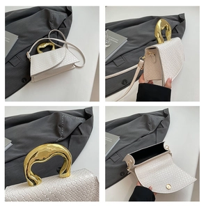 Close-up of white woven shoulder bag featuring organic gold metal handle and interior detail