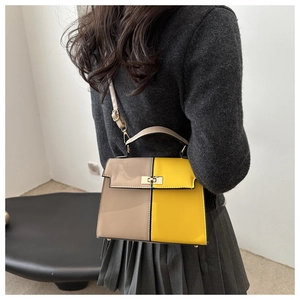 Detail view of the structured color-block crossbody bag on model with gold buckle