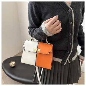 Detail of the high-texture orange and white patchwork leather handbag with gold metal lock