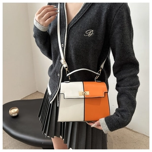 Detail of trendy color-block Kelly bag featuring orange and white leather with gold hardware