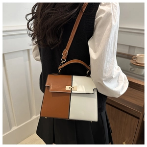 Close-up of contrast color Kelly bag with golden square twist lock and fine PU leather texture