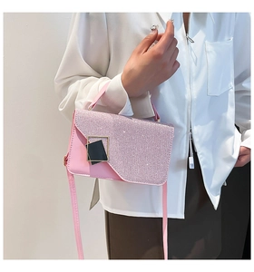 Detail of pink sequins flap and gold-framed square buckle on the leather handbag