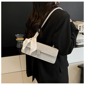 Detail of grey shoulder bag with checkered scarf and sparkling buckle on black blazer