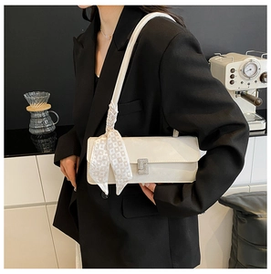 Detail of white rectangle shoulder bag with silver diamond buckle and heart print silk scarf
