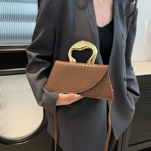 Brown crocodile embossed tote bag featuring a designer gold-tone metal handle and strap