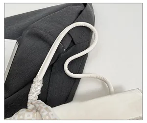 Detail of white leather shoulder bag featuring a soft strap and heart-patterned silk scarf