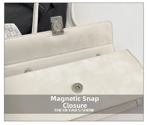Close-up of the elegant magnetic closure and smooth cream leather on this baguette bag