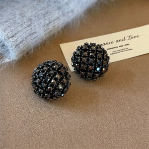 Vue détaillée de boucles d'oreilles boules avec strass noirs et placage or haut de gamme