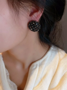 Gros plan de boucles d'oreilles vintage avec perles noires portées par un mannequin