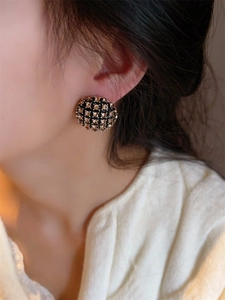 Détail macro de boucles d'oreilles rondes noires vintage avec cristaux étincelants
