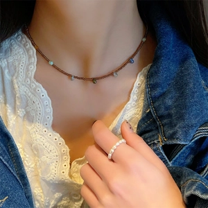 Collier bohème avec pendentifs gouttes colorés et bague en perles sur un modèle