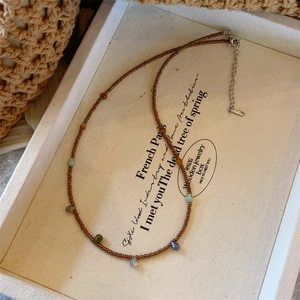 Collier de perles fait main avec pendentifs en pierres colorées sur plateau