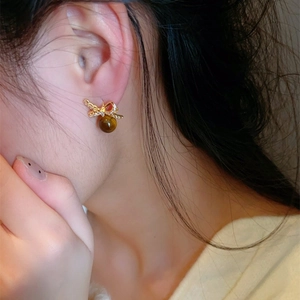Boucles d'oreilles nœud dorées avec cristaux pavés et perles en pierre œil de tigre