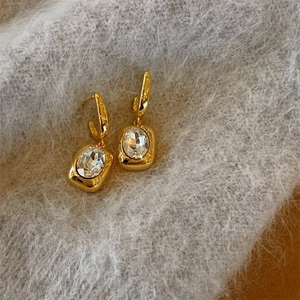 French vintage gold U-shaped earrings with square faceted crystal on plush background