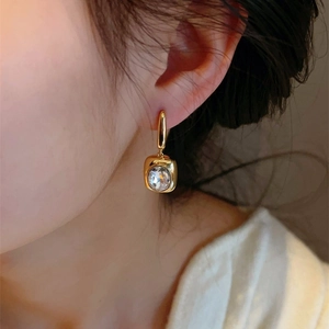 French vintage gold earrings with sparkling square crystal worn by a female model