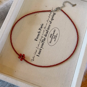 Handmade red beaded necklace with small flower charm and adjustable silver chain