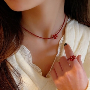 Red Czech bead jewelry set featuring flower necklace and ring on model in lace top