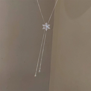 Close-up of a zirconia snowflake pendant with long silver tassels and teardrop charms