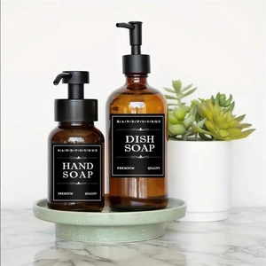 Amber glass bottles for hand and dish soap with minimalist labels on marble countertop
