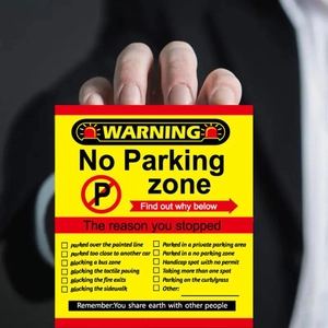 Detail of hand holding a yellow bad parking card with 12 writable violation checkboxes