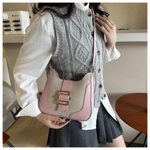 Détail de cuir rose et toile beige sur un sac à bandoulière élégant et moderne
