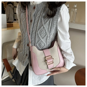 Détail du sac bandoulière en cuir rose et toile beige avec boucle en métal doré