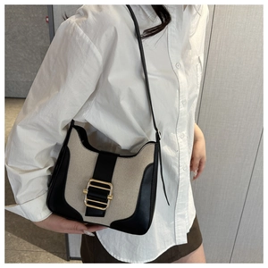 Détail d'un sac porté épaule vintage en toile beige avec une boucle carrée dorée chic