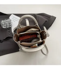 Ruime binnenkant van beige bucket bag met litchi-textuur en handige vakken voor spullen