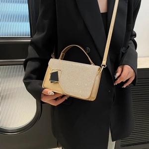 Fashionable gold shimmering crossbody handbag with geometric buckle on model