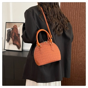 Bolso de mano marrón con textura de cocodrilo y correa ajustable en modelo