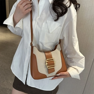 Sac à bandoulière contrasté tendance en cuir marron et toile crème avec boucle dorée