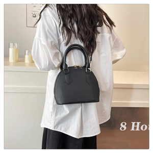 Bolso de mano negro clásico con textura de cocodrilo mostrado en un estilo de moda