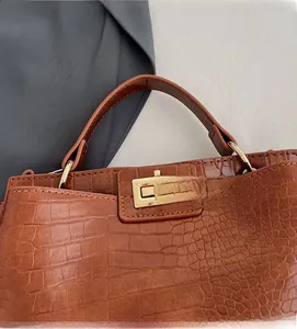 Detail of vintage brown crocodile embossed leather with gold rectangular twist lock