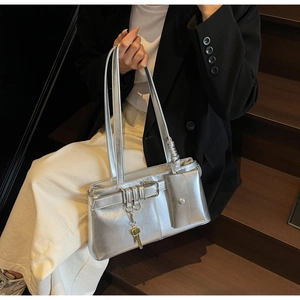 Detail showing metallic silver shoulder bag with decorative buckle and mini pouch accessory