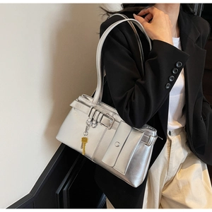 Detailed view of silver metallic underarm bag with wrap-around strap and buckle detail