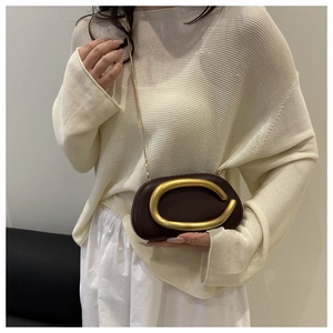Close-up of a coffee brown PU crossbody bag with a large matte gold C-shaped metal buckle
