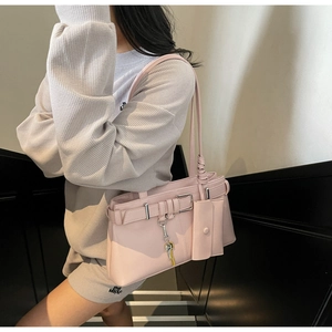 Detail of light pink tote bag with decorative buckle and hanging mini coin purse charm