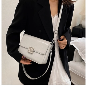 Detail of silver metallic leather crossbody bag featuring a sleek minimalist metal buckle