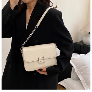 Detail of a creamy white PU leather crossbody bag with silver chain and metal buckle