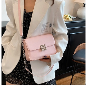 Detail of pink glossy leather shoulder bag featuring silver S-lock and chain strap