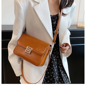 Detail of vintage brown leather handbag with silver clasp and adjustable shoulder strap