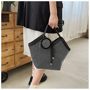 Close-up of a black tote bag with silver rhinestones and a matching round coin purse